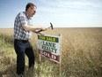 Bob Lane, of Lane Realty, puts up a for sale sign on some farm land near Regina.