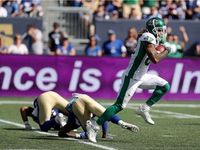 Saskatchewan Roughriders' Naaman Roosevelt, right, takes off en route to the end zone Saturday in Winnipeg.