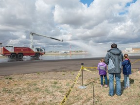 Visitors look on as firefighters demonstrate the capabilities of an Airport Rescue and Fire Fighting Rapid Intervention Vechicle during the Regina Flying Club's open house event in Regina, Saskatchewan on September 17, 2017.