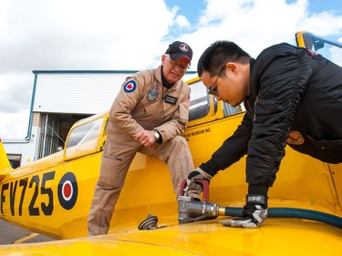 Pilot Mark Odegard of the Commonwealth Air Training Plan Museum in Brandon, Manitoba watches as a member of the ground crew refuels the PT-26 Cornell aircraft he flew to Regina, Saskatchewan for the Regina Flying Club's open house event on September 17, 2017.