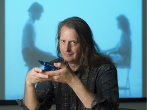 The film Wheat Soup is projected behind Gerald Saul, who holds a prop anvil that figures into the film.