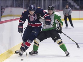 Regina Pats forward Bryce Platt is checked by Prince Albert Raiders forward Drew Warkentine during a WHL pre-season game at the Brandt Centre on Friday.