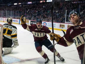 Robbie Holmes,
centre, and Wyatt Sloboshan celebrate a Regina Pats goal Saturday against the visiting Brandon Wheat Kings.