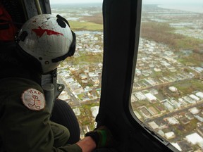 This US Navy photo obtained September 24, 2017 shows Hospital Corpsman 2nd Class Gary Haley, assigned to Helicopter Sea Combat Squadron (HSC) 7, as he conducts search and rescue operations on September 22, 2017 over San Juan, Puerto Rico following Hurricane Maria. The US Department of Defense is supporting Federal Emergency Management Agency, the lead federal agency, in helping those affected by Hurricane Maria to minimize suffering and is one component of the overall whole-of-government response effort.