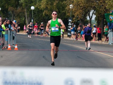 Mark Berscheid, first place finisher in the full marathon portion of the Queen City Marathon, sprints the last hundred metres to break the ribbon and cross the finish line in front of the Conexus Arts Centre in Regina, Saskatchewan on September 10, 2017.
