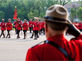 An RCMP officer among the crowd salutes fellow officers during the annual RCMP National Memorial Service at the RCMP academy in Regina, Saskatchewan on September 10, 2017.