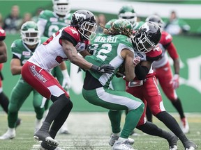 Saskatchewan receiver Naaman Roosevelt, 82, was knocked out of Sunday's game on this hit by Calgary's Tunde Adeleke, right.