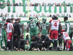 Saskatchewan Roughriders wide receiver Naaman Roosevelt (82) is attended to by team staff after getting hit by Calgary Stampeders defensive back Tunde Adeleke (27) during a CFL game held at Mosaic Stadium on September 24, 2017.