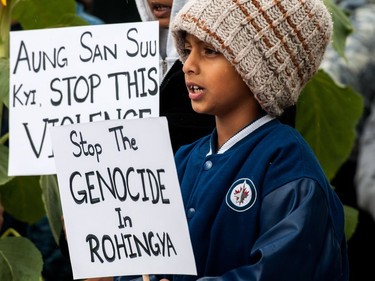 A child holds a sign as protestors gather outside of city hall in Regina, Saskatchewan to rally against violence in western Myanmar. September 16, 2017.