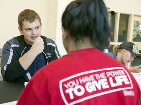 Taylor Wandler, 3rd year University of Regina student, swabs his cheeks as volunteer Siri Chiluka helps with the process in Regina.  Get Swabbed is an effort to get more people on the national stem cell database.