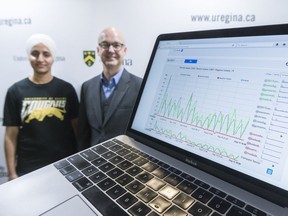 Software called "vista" is displayed on a laptop while assistant professor in the department of computing science Orland Hoeber, center, and masters student Gursimran Kaur, left, look on at a funding announcement held at the Research and Innovation Centre of the University of Regina. The software is designed to perform searches of social media platforms.