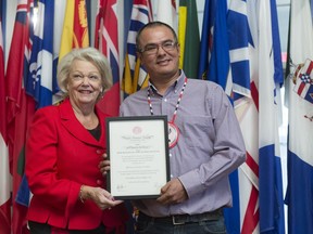 Clark Whitecalf, right, stands with Lt.-Gov. Vaughn Solomon Schofield, as he receives the Queen's Certificate for Bravery.