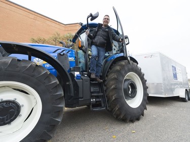 Todd Klink, chief marketing officer with FCC, steps down from the tractor that pulls a trailer of donated food during the annual FCC Drive Away Hunger tour for the Regina Food Bank.