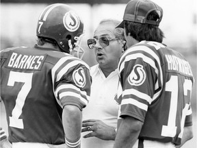 Saskatchewan Roughriders head coach Joe Faragalli chats with quarterbacks Joe Barnes, 7, and John Hufnagel, 12, in 1981.