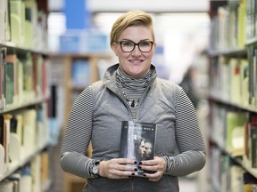 Megan McCormick, events co-ordinator for the Regina Public Library, holds the book 13 Reasons Why.