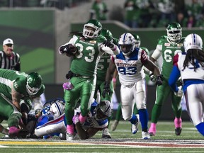 Saskatchewan Roughriders running back Trent Richardson (33) is tackled by Montreal Alouettes linebacker Kyries Hebert (34) during a CFL game held at Mosaic Stadium.