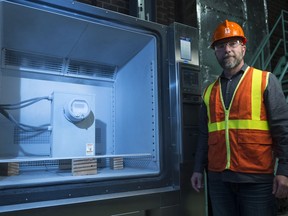 Dean Schill, manager of metering services, stands beside a smart meter undergoing a temperature test at a SaskPower testing facility.