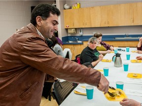 Abdulnaser Alkhalaf hands out Syrian treats at the Stories from Syria event held at the Prince of Wales library.