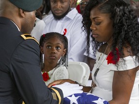 Myeshia Johnson is presented with the U.S. flag that was draped over the casket of her husband, Sgt. La David Johnson, during his burial service at Fred Hunter's Hollywood Memorial Gardens in Hollywood, Fla., on Saturday, Oct. 21, 2017.