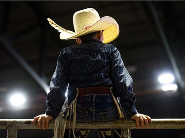 A young rider sits on the  fence and watches the action at the Steer Riding Rodeo School during Agribition on Saturday, Nov. 25, 2017, at the Brandt Centre.