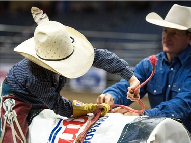 A young rider gets a lesson in how to hold his rope at the Steer Riding Rodeo School during Agribition on Saturday, Nov. 25, 2017, at the Brandt Centre.