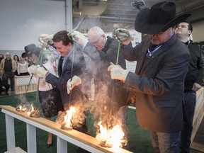 Tracy Fahlman, from left, CEO of the Regina Hotel Association, Regina Mayor Michael Fougere, Minister of Agriculture Lyle Stewart, and Bruce Holmquist, president of Canadian Western Agribition, take part in the burning of the brand on Monday, Nov. 20, 2017, to kick off the 47th annual Canadian Western Agribition in Regina.
