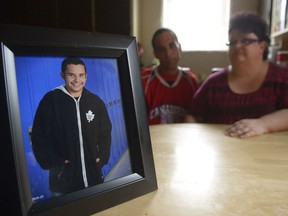 A school portrait of Kye Ball sits on the kitchen table of his parents Chris, center, and Wanda Ball, right. In March, Kye took his own life.