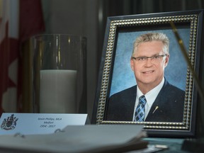 A book of condolences and a portrait of Kevin Phillips sit on a table in the rotunda of the Legislative Building. The 63-year-old MLA from Melfort died Monday.