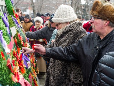 Members of the public pin poppies to the base of the cenotaph during the Remembrance Day service in Victoria Park.