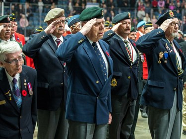 Members of the veterans company salute during the Remembrance Day service at the Brandt Centre.