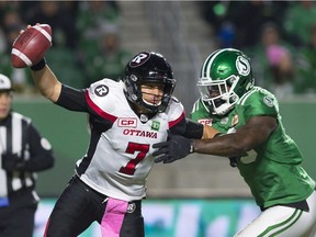 Ottawa Redblacks quarterback Trevor Harris (7) gets pressured from Saskatchewan Roughriders defensive lineman A.C. Leonard (99) during a CFL game held at Mosaic Stadium.