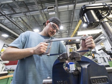 Quinn Thompson saws in a machine shop at Saskatchewan Polytechnic.