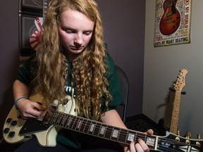 Abby Allen strums a few chords on the guitar at Regina's School of Rock during its grand opening. The school teaches teaches youth to play instruments.
