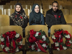 Mays Al Jamous (from left), Nour Albaradan, and Abdul Mustafa sit together in the auditorium of Sheldon-Williams Collegiate. The students will share their memories of war-torn Syria as part of the school's Remembrance Day service on Friday.