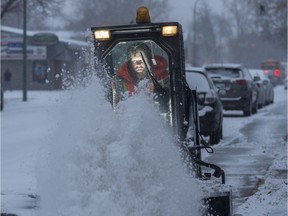 Curt Henke clears the sidewalk of newly fallen snow near Dewdney Avenue East on Wednesday.