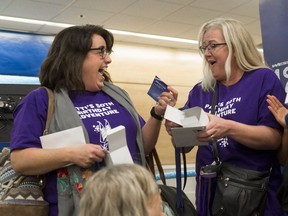 Pam Caswell, left, and Patti Wass, right, react to getting gifts from WestJet during a marketing event held at the Regina International Airport on Tuesday.