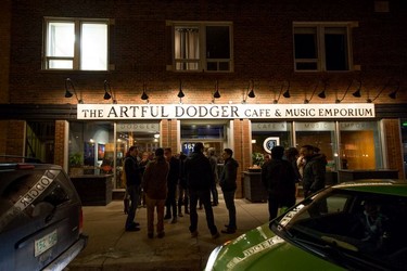 Patrons stand outside the Artful Dodger and socialize while waiting for the next band to begin its set on the venue's last night operating before its closure.