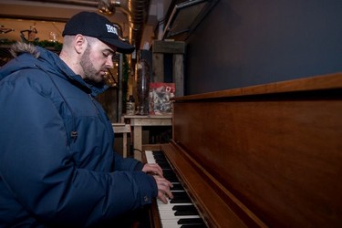 Ben Sefton plays piano and sings in the library of the Artful Dodger during the last night the business was open.