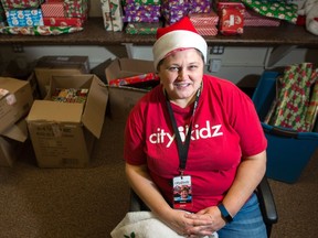 Donna West, branch manager of CityKidz in Regina, poses amidst a large collection of Christmas gifts at the Souls Harbour Rescue Mission youth center on Dewdney Avenue.