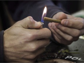 A man lights a marijuana cigarette in Denver on Tuesday, April 25, 2017. A vast majority of Canadians who participated in a recent government survey believe pot use could be habit forming.