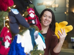 Amanda Lanoway, associate director of engagement with the United Way, holds up mittens by the mitten tree in the lobby at SaskEnergy. The organization is holding "Stuff the Sleigh Mitten Drive" to provide mittens to students in need.