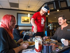 Rob Vanstone, center, veteran sports writer for the Regina Leader-Post, serves customers Faye Clark, right, and Ron Selinger at Nicky's Cafe during Nicky's Coffee Day. Leader-Post staff worked at the event serving coffee and collecting donations for the Christmas Cheer Fund.
