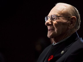 Canadian Second World War veteran and hockey hall of fame inductee Johnny Bower takes part in ceremony showing the new exhibit dedicated to First World War and Second World War veterans at the Hockey Hall of Fame in Toronto on November 10, 2014. Canadian hockey legend Johnny Bower has died. A statement from his family says the 93-year-old died after a short battle with pneumonia.