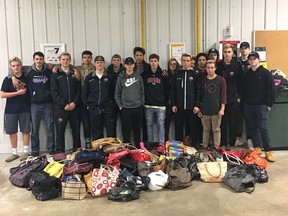Members of the Prairie Storm Extreme Hockey midget AA team pose with bags that are full of gifts for less-fortunate members of the community. The gifts are to be distributed in Regina on Sunday.