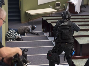 SWAT members continue to advance on the shooters. The man on the right films the simulation, which will be used later for training purposes.