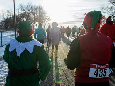 Participants run along next to Wascana Lake while taking part in the Santa Shuffle walk/run event that started at the Conexus Arts Centre in Regina on Saturday, Dec. 2, 2017.