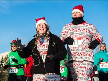 A runner waves at the camera while participating in the Santa Shuffle walk/run event that started at the Conexus Arts Centre in Regina on Saturday, Dec. 2, 2017.