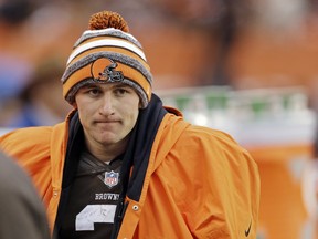 In this Dec. 14, 2014 file photo, Cleveland Browns quarterback Johnny Manziel watches from the sidelines against the Cincinnati Bengals.