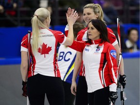 Team Canada skip Michelle Englot, who is from Regina, gives a high-five to Raunora Westcott, left, as second Leslie Wilson looks on as they celebrate a victory over B.C. at the Scotties Tournament of Hearts in Penticton, B.C., on Saturday.