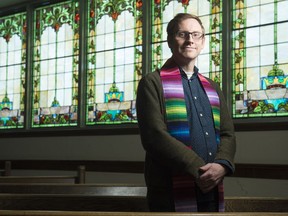 Cameron Fraser, minister of Knox-Metropolitan Church, stands in the sanctuary. The church is going through a process to become an affirming ministry, which means it will explicitly welcome people from the LGBTQ community.
